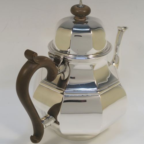 A heavy Antique Sterling Silver George I style large teapot, having a plain panelled bellied body, with a wooden scroll handle, a hinged domed lid with wooden  finial, a panelled spout, and all sitting on a collet foot. This handsome antique silver teapot was made by D. and J. Welby of London in 1918. The dimensions of this fine hand-made silver teapot are height 19 cms (7.5 inches), length 23 cms (9 inches), and the weight is approx. 700g (22.6 troy ounces).   