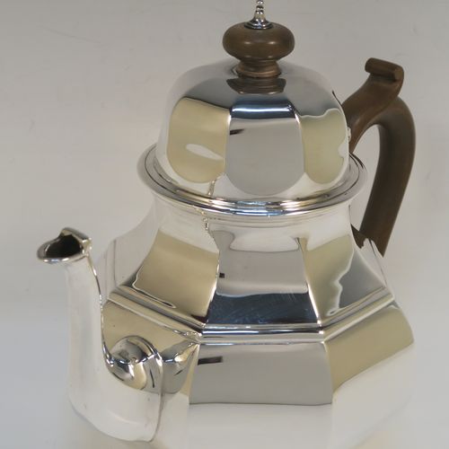 A heavy Antique Sterling Silver George I style large teapot, having a plain panelled bellied body, with a wooden scroll handle, a hinged domed lid with wooden  finial, a panelled spout, and all sitting on a collet foot. This handsome antique silver teapot was made by D. and J. Welby of London in 1918. The dimensions of this fine hand-made silver teapot are height 19 cms (7.5 inches), length 23 cms (9 inches), and the weight is approx. 700g (22.6 troy ounces).   