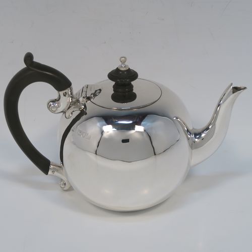 A small but beautifully made Antique Victorian Sterling Silver teapot in an early George II Bullet or Skittle Ball style, having a very plain round bellied body, a curved spout, a wooden scroll handle and finial, a hinged flat lid, and sitting flat base. This elegant silver bachelor sized teapot was made by Wakely and Wheeler of London in 1897. The dimensions of this fine hand-made silver skittle ball style teapot are length 17 cms (6.75 inches), height 11.5 cms (4.5 inches), and it weighs approx. 200g (6.5 troy ounces).   