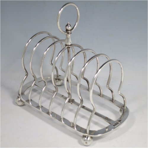 An Antique Victorian Sterling Silver large and heavy seven-bar toast-rack, having plain shaped & rounded wire-work bars, a round handle, sitting on a rectangular base with a strengthening strut, and four ball feet. Made by Walker & Hall of Sheffield in 1898. The dimensions of this fine hand-made antique silver toastrack are length 18 cms (7 inches), height 16.5 cms (6.5 inches), width 9.5 cms (3.75 inches), and it weighs approx. 382g (12.3 troy ounces).   