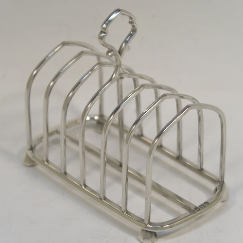 A very handsome Antique Victorian Sterling Silver seven-bar toastrack, having plain arched cross-section wire-work bars, a matching loop handle, all sitting on a rectangular base with a strengthening strut, on four cast panelled feet. This elegant antique silver toast-rack was made by Hawksworth Eyre and Co. Ltd., of Sheffield in 1898. The dimensions of this fine hand-made antique silver toast-rack are length 13 cms (5 inches), height 11.5 cms (4.5 inches), width 6.5 cms (2.5 inches), and it weighs approx. 191g (6.2 troy ounces).   