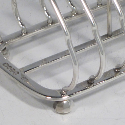 Antique Victorian sterling silver seven-bar toastrack, having shaped wire-work bars, a crossed loop handle, sitting on a rectangular base with a strengthening strut, and four cast octagonal feet. Made by Edward Gilbert of London in 1883. The dimensions of this fine hand-made silver toastrack are length 13.5 cms (5.25 inches), height 11.5 cms (4.5 inches), width 8 cms (3.25 inches), and it weighs approx. 182g (6 troy ounces).