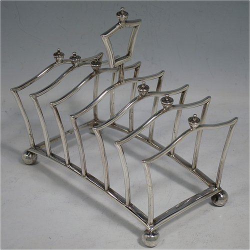 An Antique Victorian Sterling Silver Gothic style large and heavy seven-bar toast-rack, having unusual shaped square wire-work bars all with cast urn-shaped finials, a matching handle, sitting on a curved rectangular base, and four ball feet. Made by Martin & Hall of London in 1883. The dimensions of this fine hand-made antique silver toastrack are length 13.5 cms (5.25 inches), height 13 cms (5 inches), width 8 cms (3.25 inches), and it weighs approx. 222g (7.2 troy ounces).    