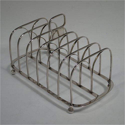 A very handsome Antique Georgian Sterling Silver seven-bar toast-rack, having rectangular shaped wire-work bars with hand-chased reeded decoration, a rectangular handle with vacant cartouche panel below, all attached to a flat rectangular base with strengthening struts, and sitting on four ball feet. Made by Joseph Biggs of London in 1816. The dimensions of this fine hand-made antique silver toast-rack are length 17 cms (6.75 inches), height 11 cms (4.25 inches), width 9 cms (3.5 inches), and it weighs approx. 162g (5.2 troy ounces).    