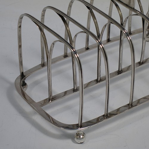 A very handsome Antique Georgian Sterling Silver seven-bar toast-rack, having rectangular shaped wire-work bars with hand-chased reeded decoration, a rectangular handle with vacant cartouche panel below, all attached to a flat rectangular base with strengthening struts, and sitting on four ball feet. Made by Joseph Biggs of London in 1816. The dimensions of this fine hand-made antique silver toast-rack are length 17 cms (6.75 inches), height 11 cms (4.25 inches), width 9 cms (3.5 inches), and it weighs approx. 162g (5.2 troy ounces).    