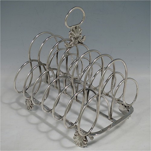 A very large and heavy Antique Georgian Sterling Silver seven-bar toast-rack, having shaped wire-work bars, a cast shell and loop handle, attached to a rectangular base with a strengthening strut, and sitting on four cast shell feet. Made by Robert and Samuel Hennell of London in 1809. The dimensions of this fine hand-made antique silver toast-rack are length 18.5 cms (7.25 inches), height 18.5 cms (7.25 inches), width 14 cms (5.5 inches), and it weighs approx. 550g (17.7 troy ounces).    