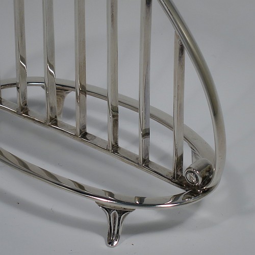 A Sterling Silver seven-bar toastrack or letter rack, having a very unusual Lyre style body with wire-work bars, a loop handle, and sitting on a base with a strengthening strut and four fluted and flanged feet. Made by Thomas Bradbury of Sheffield in 1937. The dimensions of this fine hand-made Lyre-shaped silver letter-rack or toast-rack are length 14 cms (5.5 inches), height 15 cms (6 inches), width 7 cms (2.75 inches), and it weighs approx. 202g (6.5 troy ounces).    