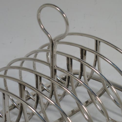 A very handsome Antique Georgian Sterling Silver seven-bar toast-rack, having oval shaped wire-work bars, a loop handle, attached to a rectangular base with a strengthening strut, and sitting on four ball feet. Made by Robinson, Edkins, and Aston of London in 1834. The dimensions of this fine hand-made antique silver toast-rack are length 15 cms (6 inches), height 12 cms (4.75 inches), width 11.5 cms (4.5 inches), and it weighs approx. 242g (7.8 troy ounces).    