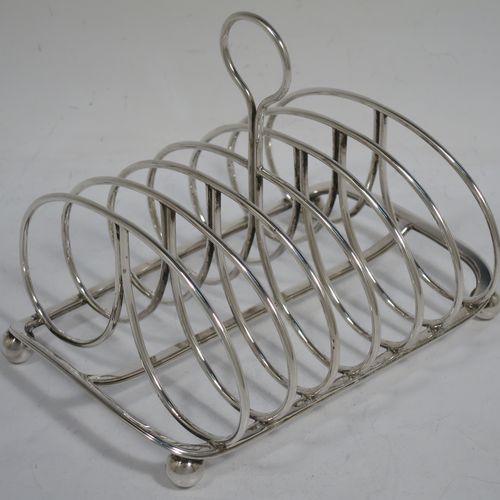 A very handsome Antique Georgian Sterling Silver seven-bar toast-rack, having oval shaped wire-work bars, a loop handle, attached to a rectangular base with a strengthening strut, and sitting on four ball feet. Made by Robinson, Edkins, and Aston of London in 1834. The dimensions of this fine hand-made antique silver toast-rack are length 15 cms (6 inches), height 12 cms (4.75 inches), width 11.5 cms (4.5 inches), and it weighs approx. 242g (7.8 troy ounces).    