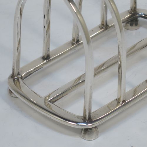 A handsome Antique Sterling Silver five-bar toastrack, having plain square cross-section wire-work bars, a matching loop handle, all sitting on a rectangular base with a strengthening strut, on four cast panelled feet. Made by Goldsmiths & Silversmiths of London in 1912. The dimensions of this fine hand-made antique silver toast-rack are length 11.5 cms (4.5 inches), height 11.5 cms (4.5 inches), width 6.5 cms (2.5 inches), and it weighs approx. 191g (6.2 troy ounces).  