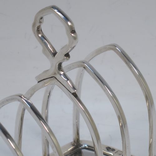 A handsome Antique Sterling Silver five-bar toastrack, having plain square cross-section wire-work bars, a matching loop handle, all sitting on a rectangular base with a strengthening strut, on four cast panelled feet. Made by Goldsmiths & Silversmiths of London in 1912. The dimensions of this fine hand-made antique silver toast-rack are length 11.5 cms (4.5 inches), height 11.5 cms (4.5 inches), width 6.5 cms (2.5 inches), and it weighs approx. 191g (6.2 troy ounces).  