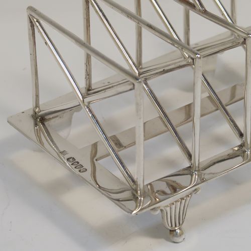 A very unusual Arts and Crafts style Antique Victorian Sterling Silver five-bar toastrack, having  square crossed wire-work bars, with a square loop handle, and sitting on a base with a strengthening strut and four fluted and flanged feet. This elegant Arts and Crafts silver toast-rack was made by Edward Hutton of London in 1881. The dimensions of this fine hand-made antique silver toast-rack are length 12.5 cms (5 inches), height 11 cms (4.3 inches), width 9 cms (3.5 inches), and it weighs approx. 259g (8.4 troy ounces).   