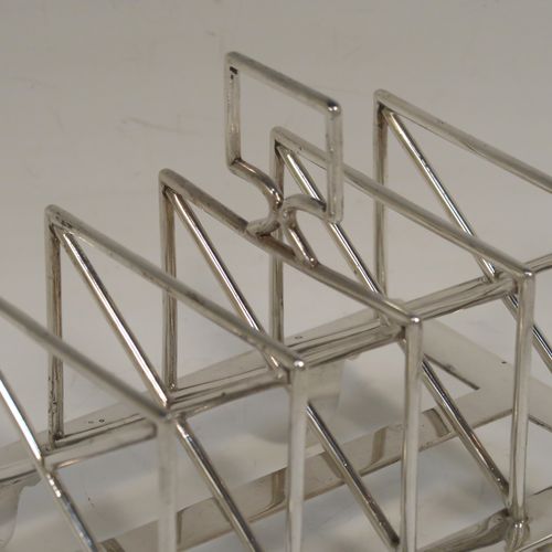 A very unusual Arts and Crafts style Antique Victorian Sterling Silver five-bar toastrack, having  square crossed wire-work bars, with a square loop handle, and sitting on a base with a strengthening strut and four fluted and flanged feet. This elegant Arts and Crafts silver toast-rack was made by Edward Hutton of London in 1881. The dimensions of this fine hand-made antique silver toast-rack are length 12.5 cms (5 inches), height 11 cms (4.3 inches), width 9 cms (3.5 inches), and it weighs approx. 259g (8.4 troy ounces).   