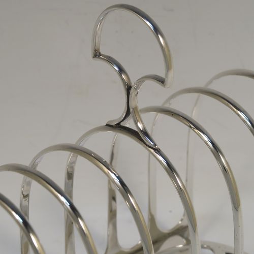 A handsome and heavy Antique Victorian Sterling Silver seven-bar toastrack, having plain rounded wire-work bars, a matching loop handle, all sitting on a rectangular base with a strengthening strut. This elegant antique silver toast-rack was made by William Hutton of London in 1898. The dimensions of this fine hand-made antique silver toast-rack are length 15 cms (6 inches), height 15 cms (6 inches), width 8 cms (3 inches), and it weighs approx. 305g (9.8 troy ounces).  