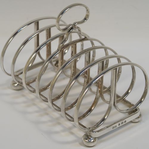 An elegant Sterling Silver seven-bar toastrack, having plain rounded cross-section wire-work bars, a loop handle, and all sitting on a rectangular base with a strengthening strut, on four cast cushion feet. This handsome silver toast-rack was made by J. B. Chatterley and Son of Birmingham in 1937. The dimensions of this fine hand-made silver toast-rack are length 12.5 cms (5 inches), height 10 cms (4 inches), width 8.5 cms (3.25 inches), and it weighs approx. 223g (7.2 troy ounces).   