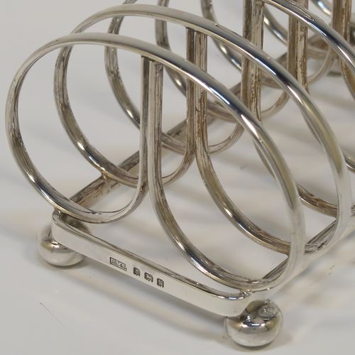 An elegant Sterling Silver seven-bar toastrack, having plain rounded cross-section wire-work bars, a loop handle, and all sitting on a rectangular base with a strengthening strut, on four cast cushion feet. This handsome silver toast-rack was made by J. B. Chatterley and Son of Birmingham in 1937. The dimensions of this fine hand-made silver toast-rack are length 12.5 cms (5 inches), height 10 cms (4 inches), width 8.5 cms (3.25 inches), and it weighs approx. 223g (7.2 troy ounces).   