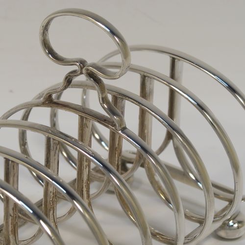 An elegant Sterling Silver seven-bar toastrack, having plain rounded cross-section wire-work bars, a loop handle, and all sitting on a rectangular base with a strengthening strut, on four cast cushion feet. This handsome silver toast-rack was made by J. B. Chatterley and Son of Birmingham in 1937. The dimensions of this fine hand-made silver toast-rack are length 12.5 cms (5 inches), height 10 cms (4 inches), width 8.5 cms (3.25 inches), and it weighs approx. 223g (7.2 troy ounces).   