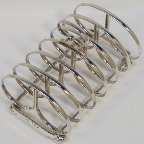 An elegant Sterling Silver seven-bar toastrack, having plain rounded cross-section wire-work bars, a loop handle, and all sitting on a rectangular base with a strengthening strut, on four cast cushion feet. This handsome silver toast-rack was made by J. B. Chatterley and Son of Birmingham in 1937. The dimensions of this fine hand-made silver toast-rack are length 12.5 cms (5 inches), height 10 cms (4 inches), width 8.5 cms (3.25 inches), and it weighs approx. 223g (7.2 troy ounces).   