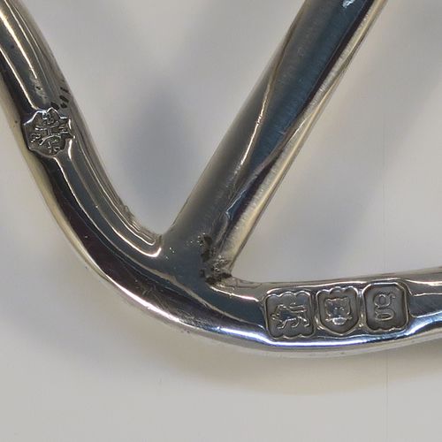 A large and very handsome Antique Edwardian Sterling Silver seven-bar toastrack, having plain arched cross-section wire-work bars, a matching  loop handle, all sitting on a rectangular base with a strengthening strut, on four ball feet. This elegant antique silver toast-rack was made by William Hutton and Sons of London in 1902. The dimensions of this fine hand-made antique silver toast-rack are length 18 cms (7 inches), height 15 cms (6 inches), width 9 cms (3.5 inches), and it weighs approx. 297g (9.6 troy ounces).  