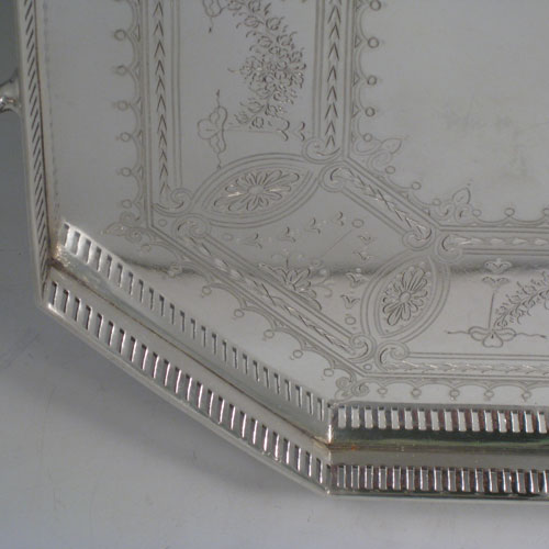 Antique Victorian silver plated tray, having an octagonal sided body, a hand-engraved ground with geometrical and floral swag decoration, a hand-pierced gallery edge, two cast reeded handles, and sitting on four cast reeded flange feet. This beautiful silver-plated tray was made by Latham and Morton in ca. 1880. The dimensions of this fine hand-made silver plated tea tray are length (inc. handles) 53 cms (21 inches), width 33 cms (13 inches).   