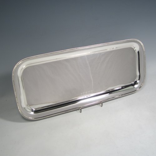 Sterling silver sandwich tray, having a rectangular body with rounded corners, a very plain ground, a raised  border with an applied gadroon edge, and sitting on a flat base. Made by the Barker Brothers  of Birmingham in 1921. The dimensions of this fine hand-made silver sandwich tray are length 39.5 cms (15.5 inches), width 17 cms (6.75 inches), and it weighs approx. 640g (20.6 troy ounces).   