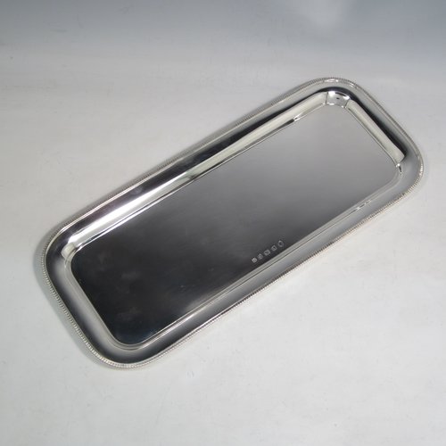 Sterling silver sandwich tray, having a rectangular body with rounded corners, a very plain ground, a raised  border with an applied gadroon edge, and sitting on a flat base. Made by the Barker Brothers  of Birmingham in 1921. The dimensions of this fine hand-made silver sandwich tray are length 39.5 cms (15.5 inches), width 17 cms (6.75 inches), and it weighs approx. 640g (20.6 troy ounces).   