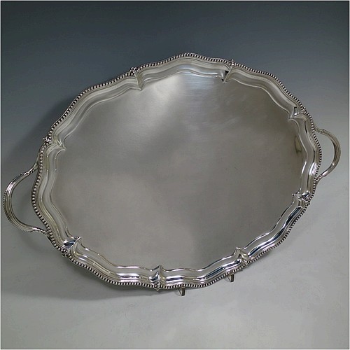 A very pretty Antique Victorian Sterling Silver tray, having a shaped oval body with a plain ground, an applied bead-edged border, and two cast reeded handles, all sitting on a flat base. This beautiful silver tray was made by John Brashier of London in 1879. The dimensions of this fine hand-made antique silver tray are length 60 cms (23.5 inches), width 39.5 cms (15.5 inches), and it weighs approx. 2,110g (68 troy ounces).    