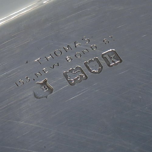 An Antique Edwardian heavy Sterling Silver Georgian style tea tray, having a rectangular body with rounded cut corners, a very plain ground with a centrally engraved crest, an applied reeded border, two cast scroll side-handles, and sitting on four cast flanged feet. Made by Thomas Bradbury of London in 1905. The dimensions of this fine hand-made antique silver tray are length (inc. handles) 53 cms (20.75 inches), width 35 cms (13.75 inches), and it weighs approx. 2,325g (75 troy ounces). Please note that this item is crested.