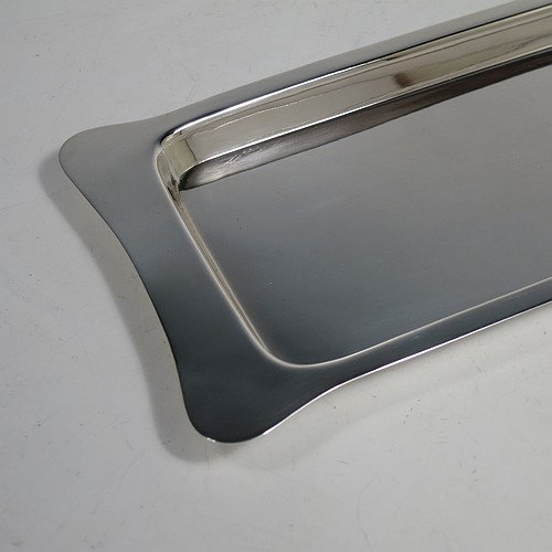 An Antique Edwardian Sterling Silver sandwich tray, having a long plain rectangular body, a very plain ground, a plain border with lobed corner handles, and sitting on a flat base. Made by Heath and Middleton of Birmingham in 1908. The dimensions of this fine hand-made antique silver sandwich tray are length 46 cms (18 inches), width 13.5 cms (5.25 inches), and it weighs approx. 506g (16.3 troy ounces). 