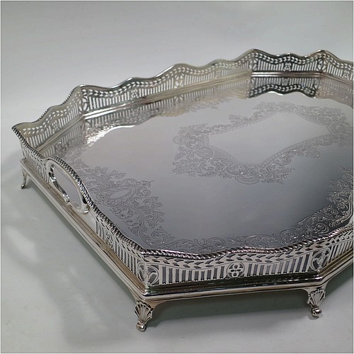 A very pretty Antique Victorian Sterling Silver gallery tray, having an elongated octagonal body, a hand-engraved ground with floral and scroll decoration, hand-pierced gallery sides with applied gadroon borders and oval cut-out handles, and sitting on eight cast shell flange feet. This beautiful silver tray was made by Charles Clement Pilling of Sheffield in 1901. The dimensions of this fine hand-made antique silver tray are length 57 cms (22.5 inches), width 41 cms (16 inches), height 8 cms (3 inches), and it weighs approx. 3,720g (120 troy ounces).    