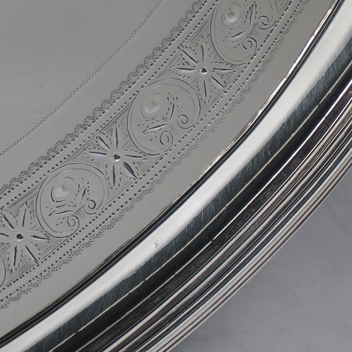 An Antique Georgian Sterling silver oval two-handled tea tray, with a beautifully hand-engraved band of floral decoration, an applied reeded border with matching cast handles, and sitting on a flat base. This handsome Georgian sterling silver tray was made by Elizabeth Jones of London in 1794. The dimensions of this fine hand-made silver tray are length inc. handles 52 cms (20.5 inches), width 34 cms (13.5 inches), and it weighs approx. 1,593g (51 troy ounces).   