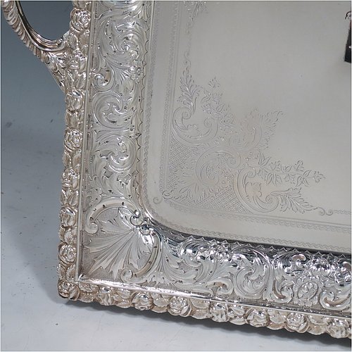 A very pretty Antique Victorian Silver Plated tray, having a rectangular body, a beautiful hand-engraved ground with floral decoration surrounding a central vacant cartouche, a hand-chased border with floral and scroll decoration, with two cast gadroon side-handles, and sitting on a flat base. This beautiful silver-plated tray was made by the Mappin Brothers of Sheffield in their top-quality Queens Plate. The dimensions of this fine hand-made silver plated tea tray are length (inc. handles) 58 cms (22.75 inches), width 38 cms (15 inches).    