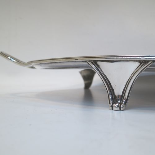 A very elegant Antique Georgian Sterling Silver tray, having an oval body with a plain central ground surrounded by a band of hand-engraved acorn and oak leaf decoration, with an applied reeded border, and two cast reeded handles, all sitting on four cast flange feet. This beautiful antique silver tray was made by Peter, Anne, and William Bateman of London in 1802. The dimensions of this fine hand-made antique silver tray are length (inc. handles) 55 cms (21.75 inches), width 35.5 cms (14 inches), height 4.5 cms (1.75 inches), and it weighs approx. 1,795g (58 troy ounces).   