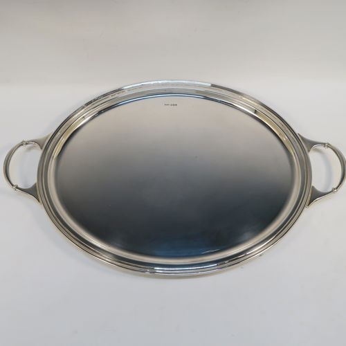 A very elegant Sterling Silver oval two-handled tea tray, having a plain ground, with an applied Reeded border, two cast side handles, and all sitting on four cast claw and ball feet. This very handsome silver tray was made by Sydney Segal of Sheffield in 1972. The dimensions of this fine hand-made silver tray are length (inc. handles) 51 cms (20 inches), width 33 cms (13 inches), and it weighs approx. 1,798g (58 troy ounces).   