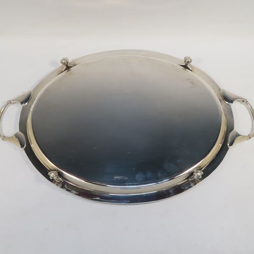 A very elegant Sterling Silver oval two-handled tea tray, having a plain ground, with an applied Reeded border, two cast side handles, and all sitting on four cast claw and ball feet. This very handsome silver tray was made by Sydney Segal of Sheffield in 1972. The dimensions of this fine hand-made silver tray are length (inc. handles) 51 cms (20 inches), width 33 cms (13 inches), and it weighs approx. 1,798g (58 troy ounces).   