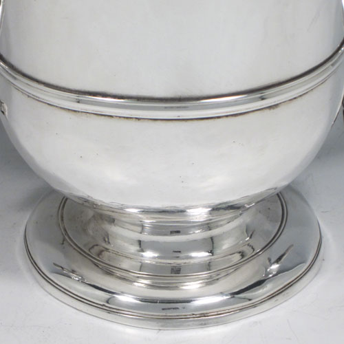 Antique Georgian George II Sterling silver trophy loving cup, having a plain round body with central reeded band, two scroll side-handles which are part-marked with a makers mark, and sitting on a pedestal foot. Made by Benjamin Blakely of London in 1738. The dimensions of this fine silver loving cup are height 14.5 cms (5.75 inches), spread across handles 23 cms (9 inches), and it weighs approx. 511g (16.5 troy ounces).