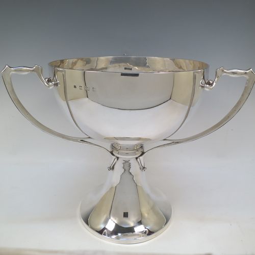 A very large and heavy Antique Edwardian Sterling Silver Art Nouveau three-handled trophy cup, having a plain round body, with three side-handles, and sitting on a plain pedestal foot. Made by Alexander Clarke & Co., of Birmingham in 1907. The dimensions of this fine hand-made large antique silver trophy cup are height 31 cms (12.25 inches), diameter of main body 27 cms (10.5 inches), and it weighs approx. 2,485g (80 troy ounces).  