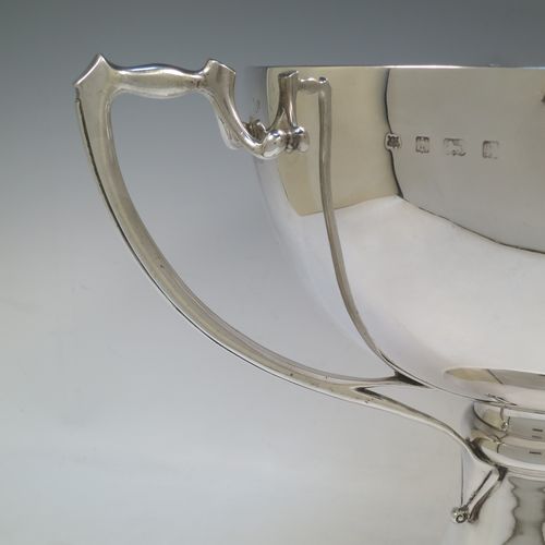 A very large and heavy Antique Edwardian Sterling Silver Art Nouveau three-handled trophy cup, having a plain round body, with three side-handles, and sitting on a plain pedestal foot. Made by Alexander Clarke & Co., of Birmingham in 1907. The dimensions of this fine hand-made large antique silver trophy cup are height 31 cms (12.25 inches), diameter of main body 27 cms (10.5 inches), and it weighs approx. 2,485g (80 troy ounces).  