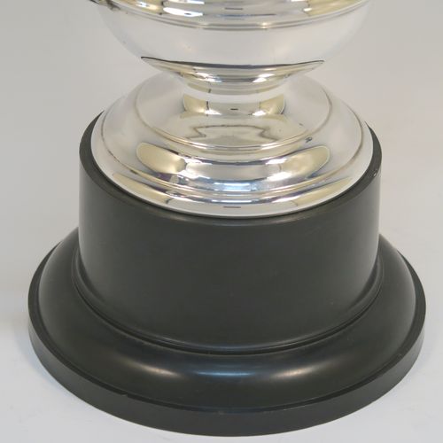 An elegant Sterling Silver trophy loving cup and plinth, having a plain round body with a central reeded band, two scroll side-handles, and sitting on a round pedestal foot, and original black Bakelite plinth. This handsome silver loving cup trophy was made by A. E. Poston & Co., of Birmingham in 1936. The dimensions of this fine silver loving trophy cup are (without plinth) height 16.5 cms (6.5 inches), spread across handles 20 cms (8 inches), and it weighs approx. 240g (7.7 troy ounces).  