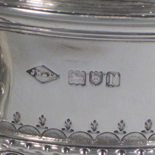 Antique Sterling silver trophy cup and cover, in a George II style, having a round body with hand-chased fluted and floral decoration, two scroll side-handles, a pull-off lid with cast finial, and sitting on a pedestal foot. Made Johnson, Walker & Tolehurst of London in 1912. The dimensions of this fine hand-made silver trophy cup and cover are height 24 cms (9.5 inches), spread across arms 26.5 cms (10.5 inches), and it weighs approx. 1,056g (34 troy ounces).   