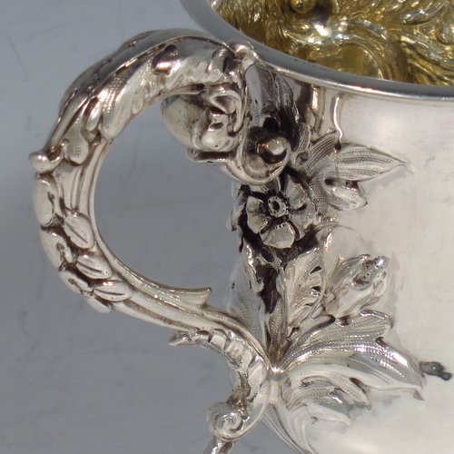 An Antique Victorian Sterling silver miniature trophy cup, in a Campana style, having a baluster body with a vacant cartouche on one side, and hand-chased floral decoration, with two cast floral scroll handles, a gold-gilt interior, and sitting on a spreading Acanthus leaf pedestal foot. Made by Charles Fox of London in 1839. The dimensions of this fine antique silver trophy cup are height 11 cms (4.25 inches), spread across handles 14 cms (5.5 inches), and it weighs approx. 185g (6 troy ounces).    