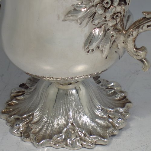 An Antique Victorian Sterling silver miniature trophy cup, in a Campana style, having a baluster body with a vacant cartouche on one side, and hand-chased floral decoration, with two cast floral scroll handles, a gold-gilt interior, and sitting on a spreading Acanthus leaf pedestal foot. Made by Charles Fox of London in 1839. The dimensions of this fine antique silver trophy cup are height 11 cms (4.25 inches), spread across handles 14 cms (5.5 inches), and it weighs approx. 185g (6 troy ounces).    