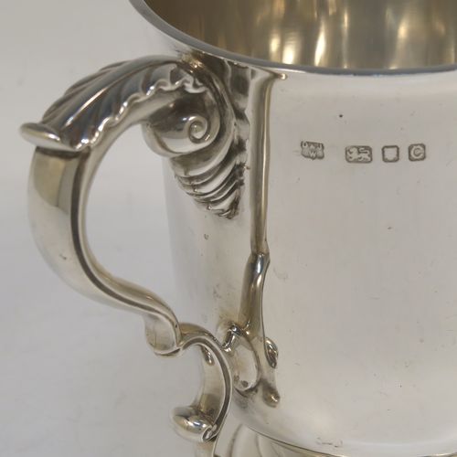 A very handsome and heavy Sterling Silver trophy cup in a George III neoclassical style, having a plain round body with tapering sides, two cast scroll side-handles with anthemion leaf decoration, and all sitting on a stepped pedestal foot. This beautiful sterling silver trophy cup was made by D. and J. Welby of London in 1938. The dimensions of this fine hand-made silver trophy cup are height 12.5 cms (5 inches), spread across arms 18 cms (7 inches), and it weighs approx. 414g (13.4 troy ounces).  