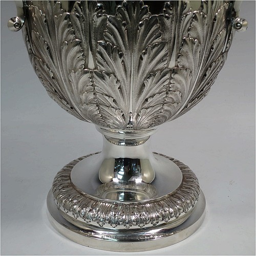 A very large, heavy, and handsome Antique Edwardian Sterling Silver three-handled trophy cup, having a round body with tapering sides and hand-chased half anthemion leaf decoration, with a  gold-gilt interior, three cast flying scroll handles with leopard face terminals, and all sitting on a pedestal foot. Made by Goldsmiths and Silversmiths of London in 1905. The dimensions of this fine hand-made large antique silver trophy cup are height 43 cms (17 inches), spread across arms 38 cms (15 inches), and it weighs approx. 3,225g (104 troy ounces).    