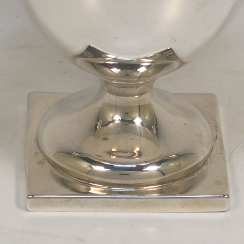 A small but very elegant Antique Victorian Sterling Silver trophy cup in a George III neoclassical style, having a round plain body with tapering sides, a gold-gilt interior, with two applied bead top borders, two scroll side-handles,  and all sitting on a pedestal foot with a square base. This handsome antique silver trophy cup was made by Angel and Savory of London in 1890. The dimensions of this fine hand-made antique silver trophy cup are height 12 cms (4.75 inches), spread across arms 16 cms (6.3 inches), and it weighs approx. 182g (5.9 troy ounces).  