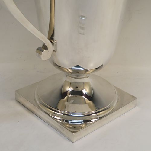 A large and handsome Art Deco style Sterling Silver trophy cup, having a plain round body with tapering sides, two plain square cross-section side-handles, with an applied upper band of geometric style decoration, and all sitting on a pedestal foot with a square base. This elegant Art Deco silver trophy cup was made by Mappin and Webb of London in 1927. The dimensions of this fine hand-made silver trophy cup and are height 32.5 cms (12.75 inches), spread across arms 31.5 cms (12.5 inches), and it weighs approx. 1,433g (46 troy ounces).   