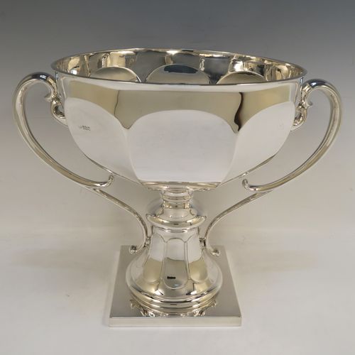 A very handsome and heavy Antique Edwardian Sterling Silver two-handled trophy cup bowl, having a plain hexagonal panelled body, two cast scroll side-handles, and sitting on a square pedestal foot. This elegant antique silver trophy bowl cup was made by Charles Clement Pilling of Sheffield in 1909. The dimensions of this fine hand-made sterling silver trophy cup bowl are height 28.5 cms (11.25 inches), width across handles 37 cms (14.5 inches), and it weighs approx. 2,133g (68.8 troy ounces).   