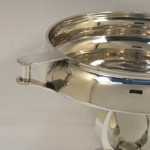 An unusual Art Deco style Sterling Silver two-handled trophy cup bowl, having a plain round body with two side-handles and flat thumb-pieces, all sitting on a round pedestal foot with four convex and square cross-section arms. This beautiful Art Deco silver trophy bowl was made in Birmingham in 1934. The dimensions of this fine hand-made sterling silver trophy cup bowl are height 17 cms (6.75 inches), width across handles 26.5 cms (10.5 inches), and it weighs approx. 589g (19 troy ounces).   