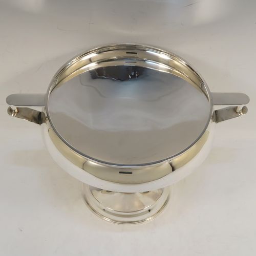 An unusual Art Deco style Sterling Silver two-handled trophy cup bowl, having a plain round body with two side-handles and flat thumb-pieces, all sitting on a round pedestal foot with four convex and square cross-section arms. This beautiful Art Deco silver trophy bowl was made in Birmingham in 1934. The dimensions of this fine hand-made sterling silver trophy cup bowl are height 17 cms (6.75 inches), width across handles 26.5 cms (10.5 inches), and it weighs approx. 589g (19 troy ounces).   