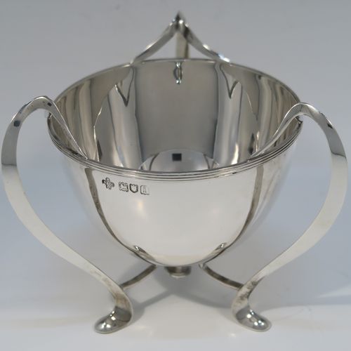 A small but very elegant and heavy Antique Edwardian Sterling Silver three-handled Loving cup bowl, having a plain round body with tapering sides and an applied reeded top border, sitting on three scroll side-handled feet. This handsome antique silver loving cup trophy bowl was made by Horace Woodward of London in 1904. The dimensions of this fine hand-made sterling silver trophy cup bowl are height 11 cms (4.25 inches), diameter of main body 10 cms (4 inches), and it weighs approx. 242g (7.8 troy ounces).   